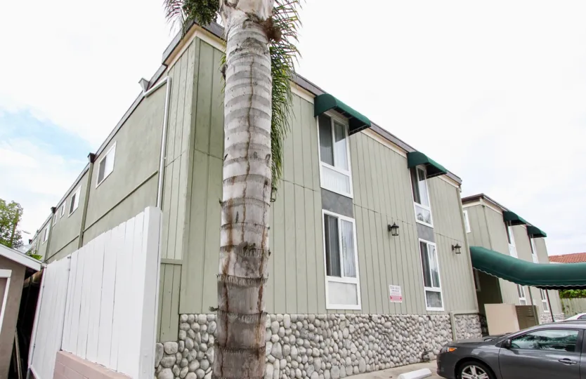 Mississippi Townhomes community North Park California palm trees stone facing green windows awning over entrance and windows fence