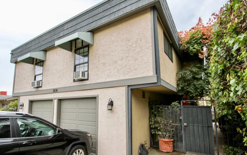 Two story residential building with garages and security gate at Morley Field Townhomes in North Park California