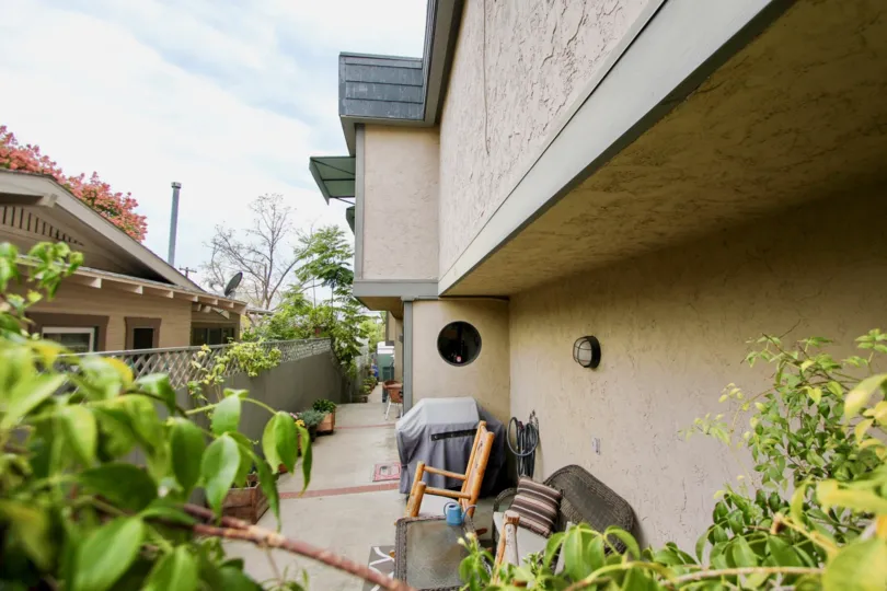 Chairs and flower pots is placed and dishes are connected in the roof the house