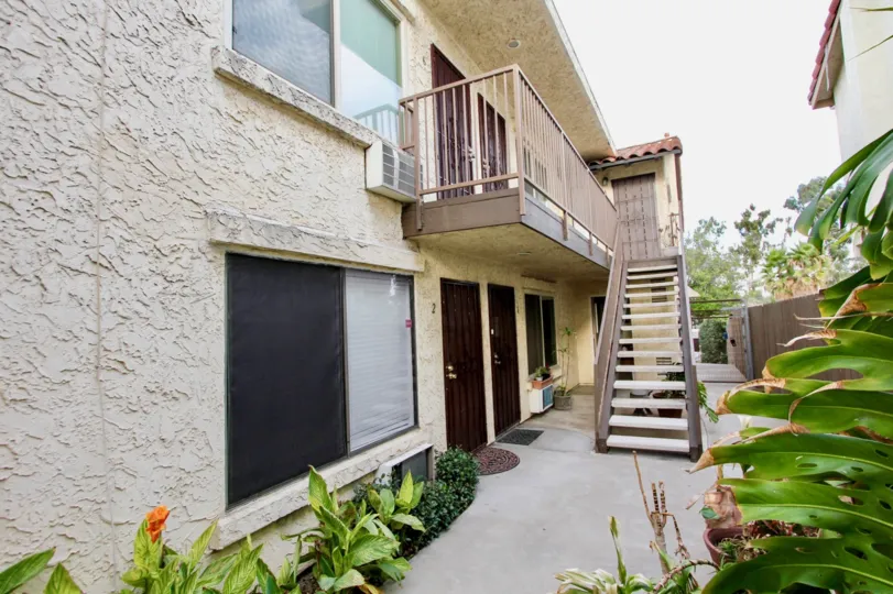 Walkway between plants with doormats leading to Nile Street Condos in North Park, California