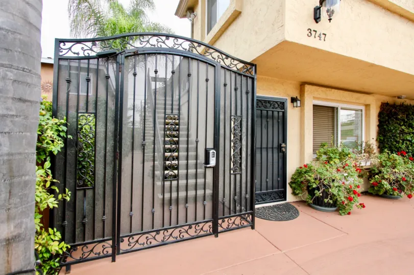 A number keypad sits on a black gate at North Park Villas