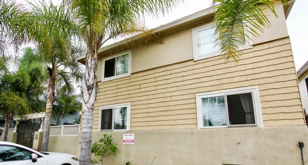 A yellow house with palm trees in front in Pacific Palms, North Park, California