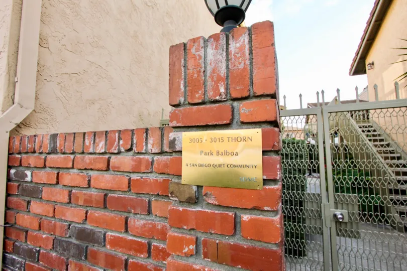 In brick wall, A board mentioned as A san Diego quiet Community 3005-3015 thron