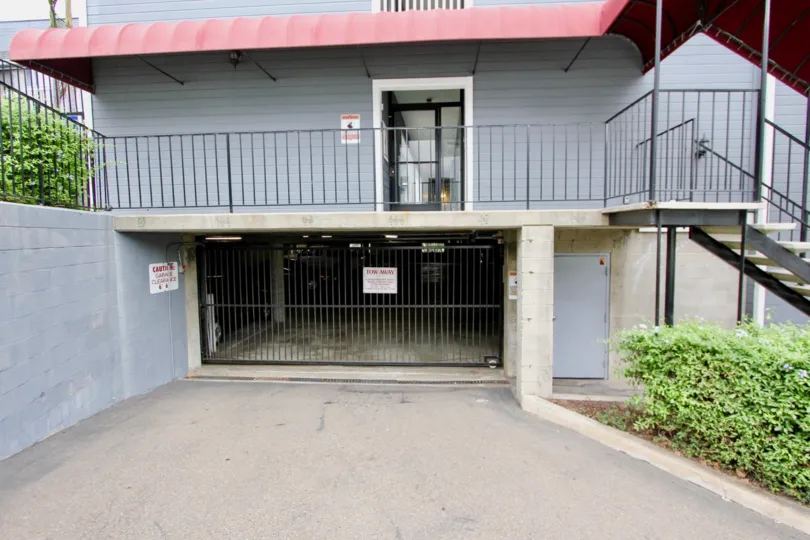 Blue brick garage entrance in Parkside with trimmed hedges and a gate