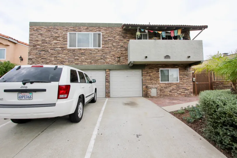The car with plate 6HPE066 is parked in front of the house