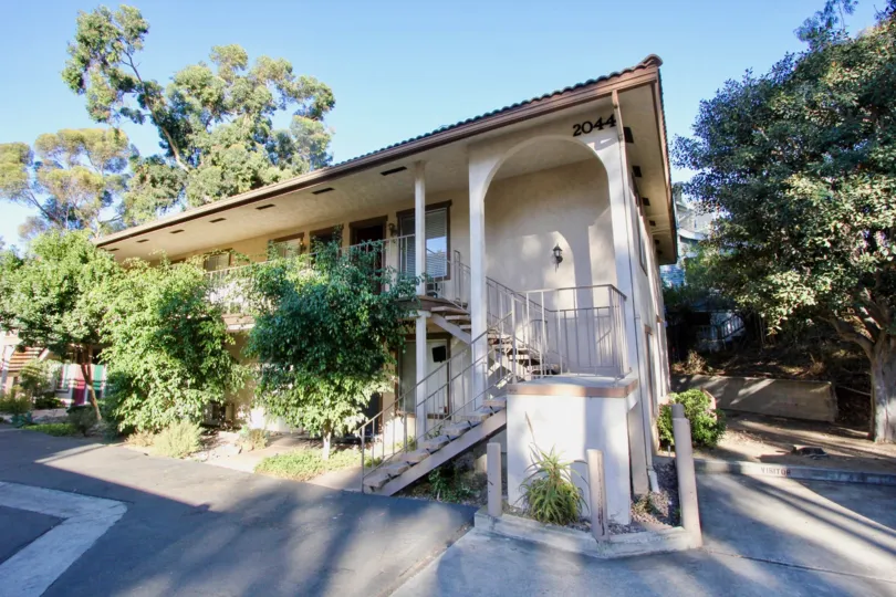 A sunny day in the Robinson Street with a beautiful house surrounded by trees.