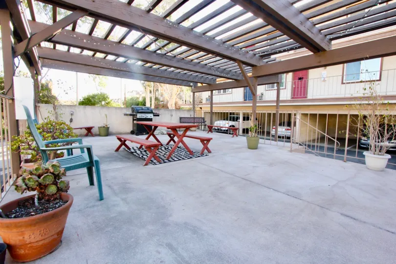 Under the roof coverage has seating tables and chairs with flower pot, dustbin