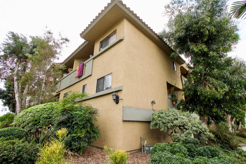 The exterior of Spanish Oaks I is llush with green trees and shrubs