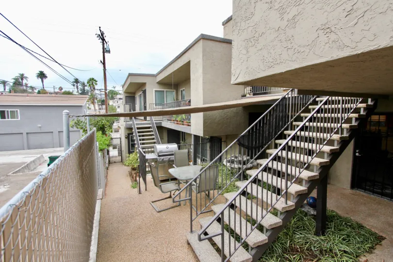 Patio of residence with table, BBQ. and two ladders in the Sunburst Court