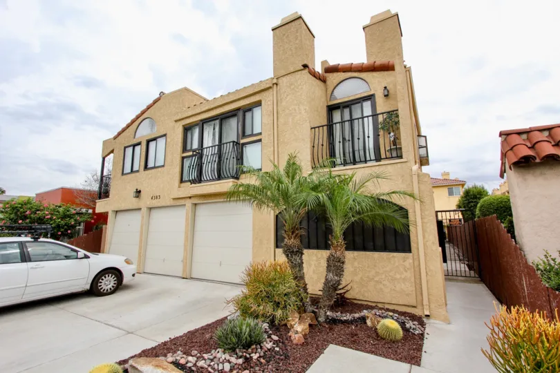 A sunny day in the area of Sunflower, condos, gated entrance, palm tree, fence, cars