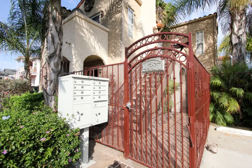 Beautiful iron gate sourrounded by plants and trees at Swift Park in North Park, California.