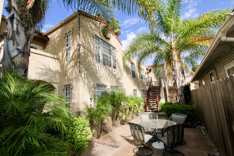 A sunny exterior shot of the staircase and patio area of Swift park with palm trees