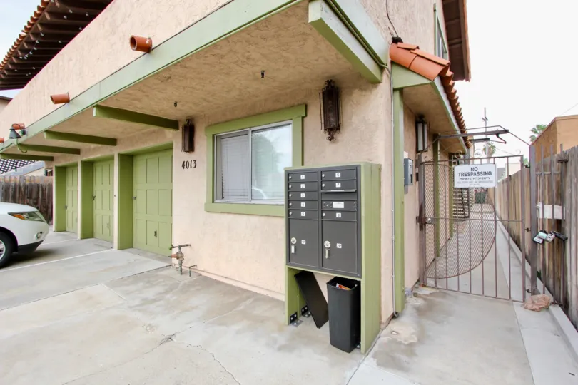 A sunny day in the area of Texas Street Condos, mailboxes, gate, garage, car