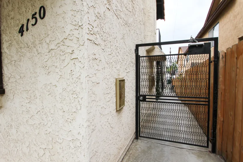 A fence door and someones address on a gloomy day In California