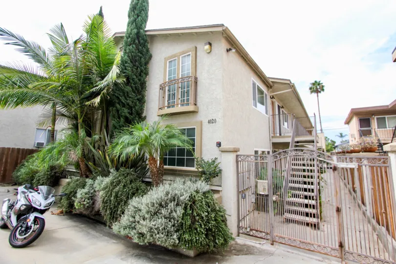 The Garden District. North Park, CA.Two story complex with trees and a gate. Side and front view.