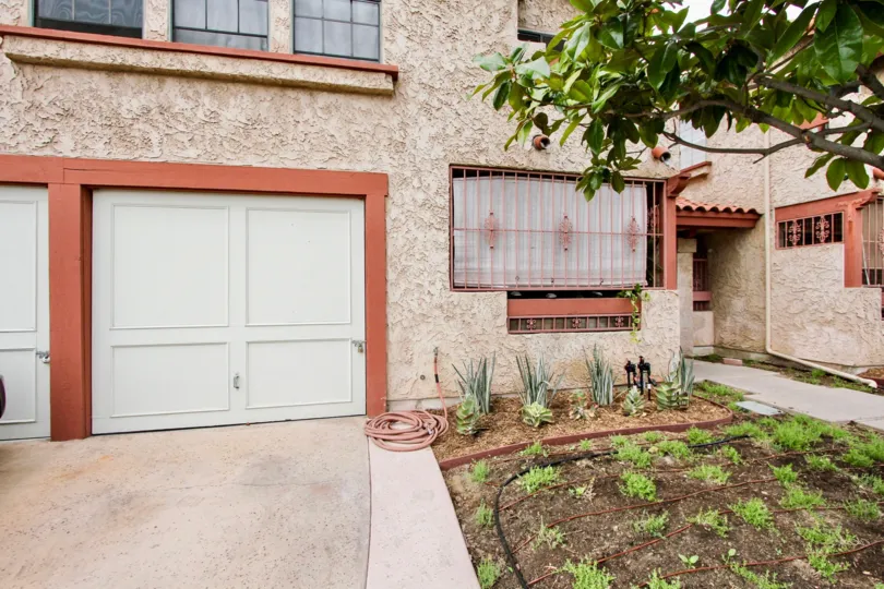 Front of a house with garage door, front yard with small plants in the Utah Park II