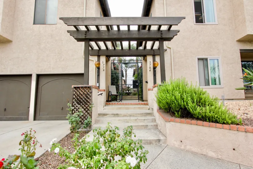 Outside view of a creme colored unit with a gated entrance and garages located in Villa Park of North Park, CA