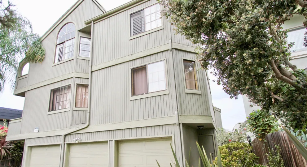 The front porch and garages of a sand colored apartment complex in the Villa Terrace Community in North Park, California