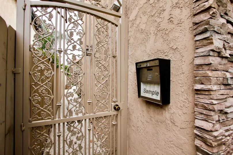 Metal intercom at pink gate inside Villas on Idaho at North Park CA