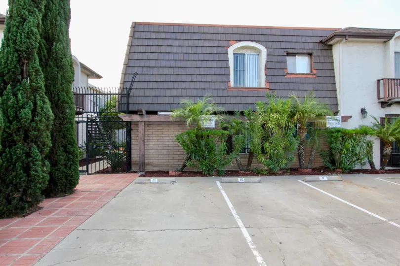 a sunny day in the area of Wilson Court, driveway, trees, condos, gate