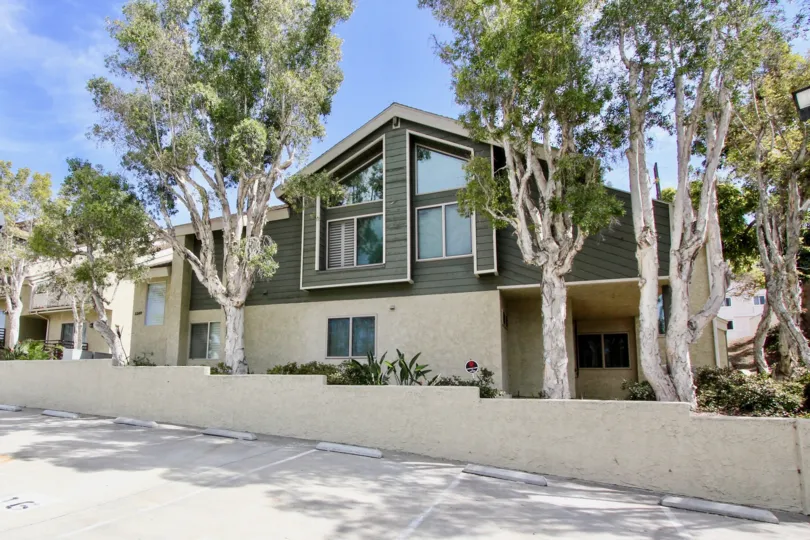 Earthy green and beige home with multiple parking spots, located in Bay Pointe, Ocean Beach, California.