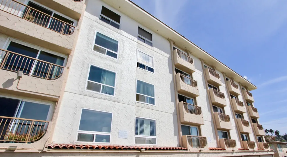 Apartment style units with semi-private balconies and textured stucco exteriors in Ocean Beach