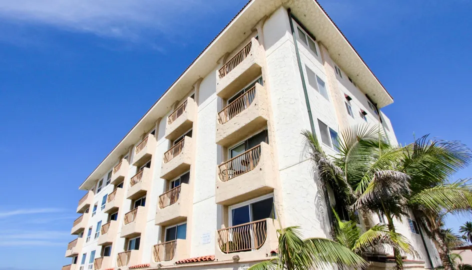 A five story condo building at Casa De La Playa sits under a deep blue sky