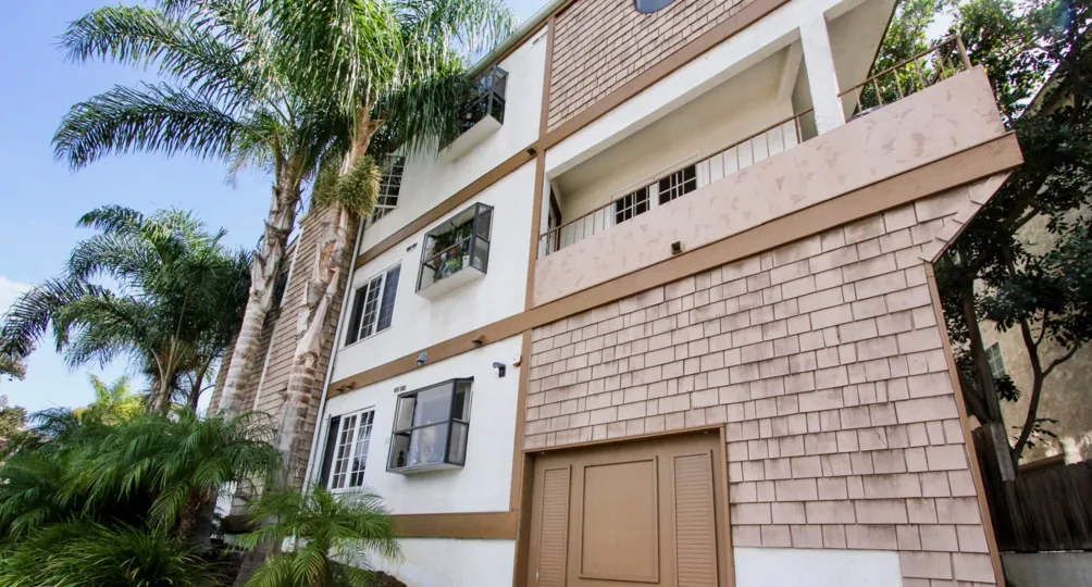 A brown and white shingled building with balcony in Ocean Beach, CA