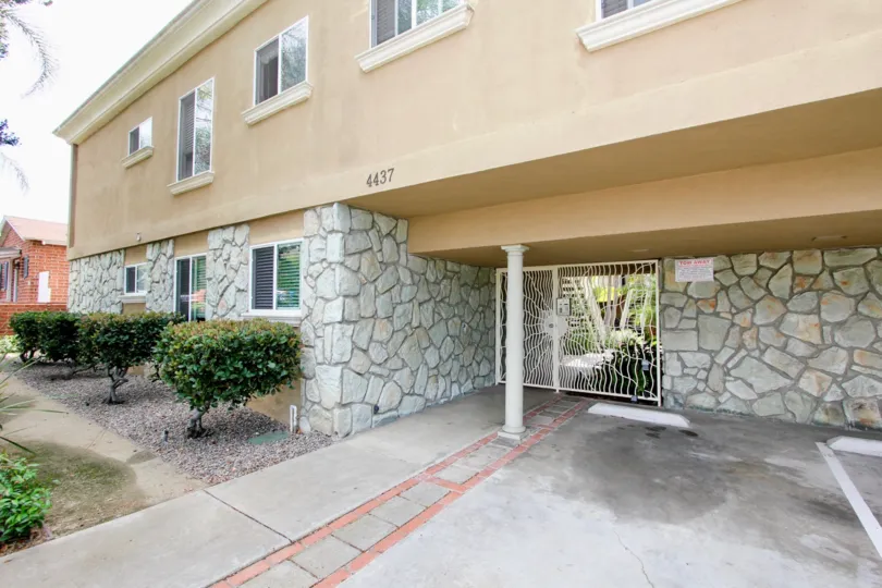 Decorative metal security entry door and covered parking with adjacent gravel paved sidelawns at Mentone Villas