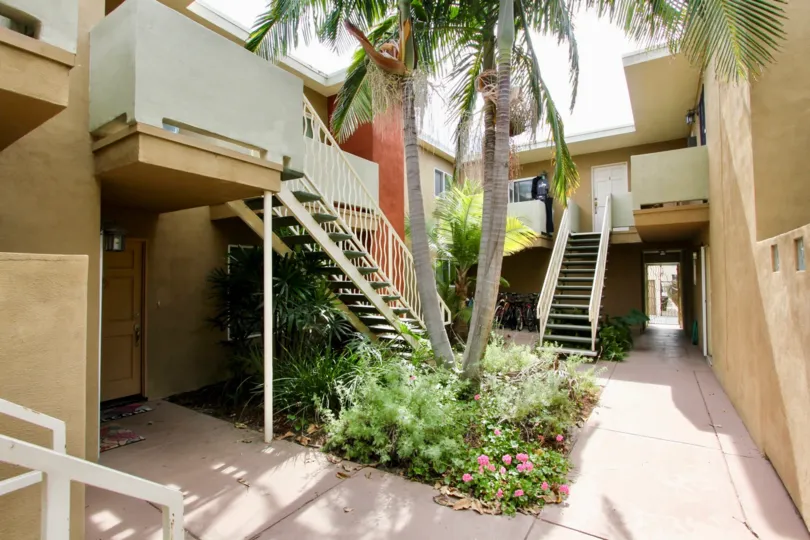 Steps entrance decorated with trees and plants with flowers in Mentone Villas