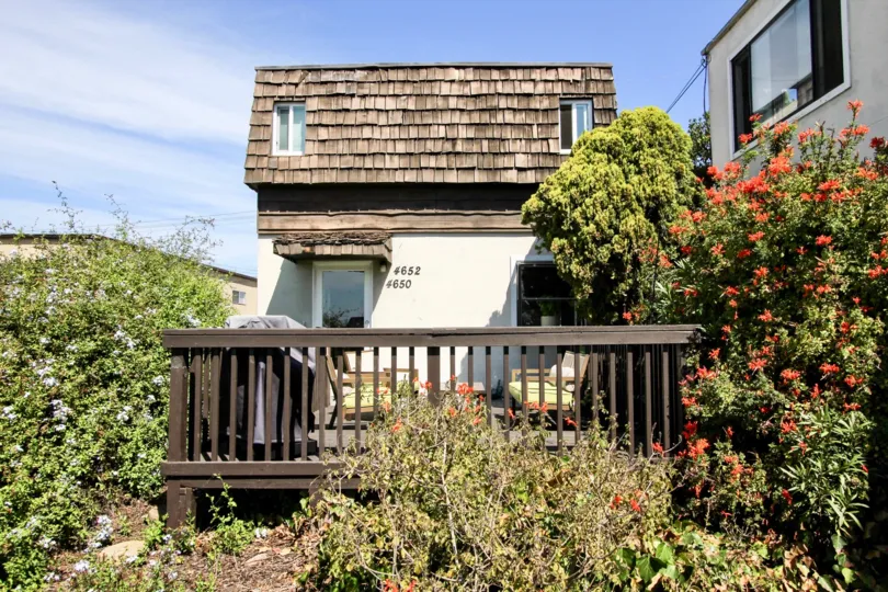 A raised brown & white home with wood tiles located at Narragansett Villas in Ocean Beach CA