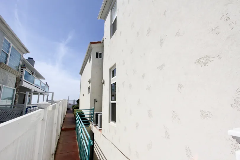 A narrow passage between white houses in Ocean Front Condos