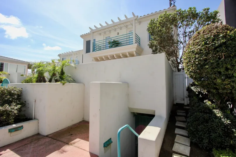 Entrance view of the building with trees and plants in Ocean Front Condos