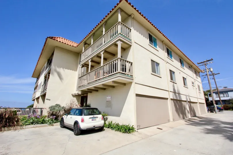 side view of the building have wooden balconies and car parked in front of the building in Oceanus