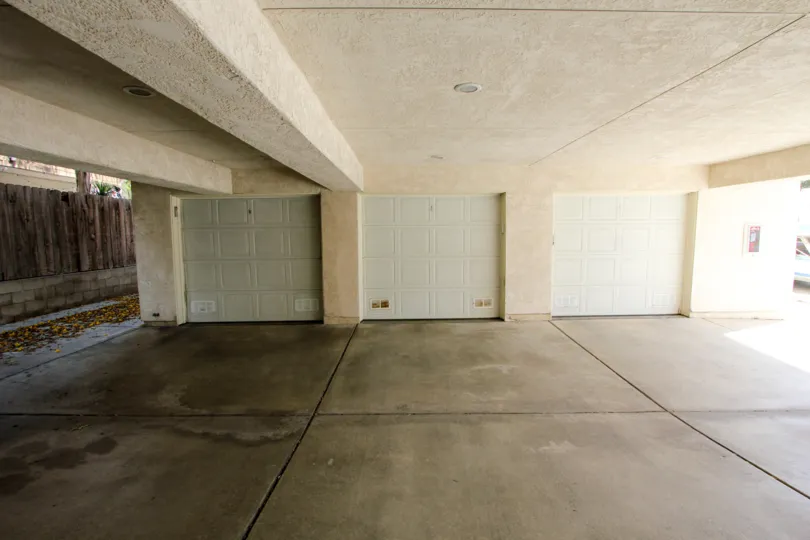 Large 3-door parking garage, open on the sides, located in Poinsettia Villas, Ocean Beach, California.