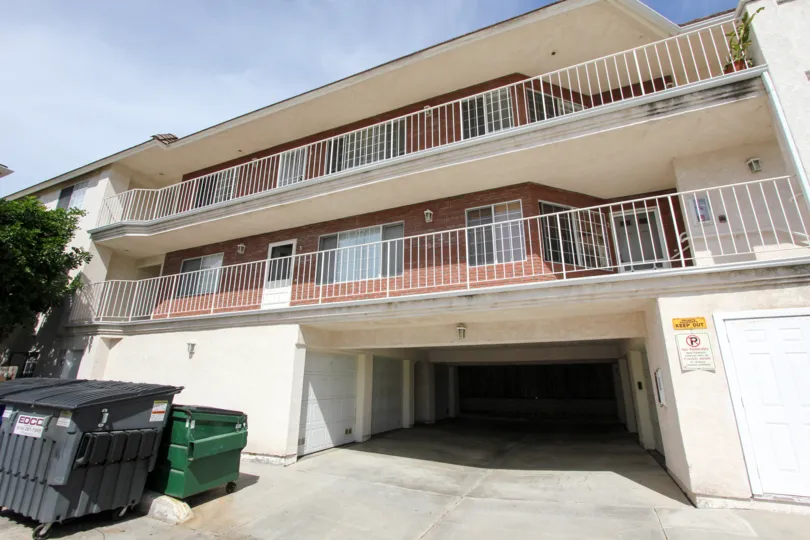 Three story town home building with dark underground parking area in Ocean Beach CA at Poinsettia Villas