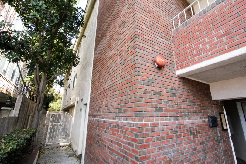 Brick design wall building have trees and plants near in Poinsettia Villas