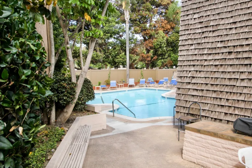 pool decorated with chairs trees and plant0s inside the compound in Point Loma Villas