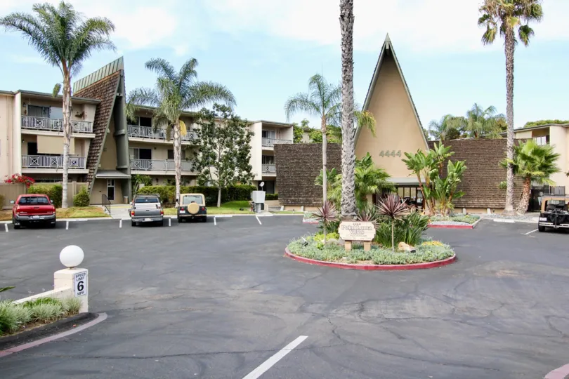 A round patch of garden sits in the middle of a parking lot at Point Loma Villas