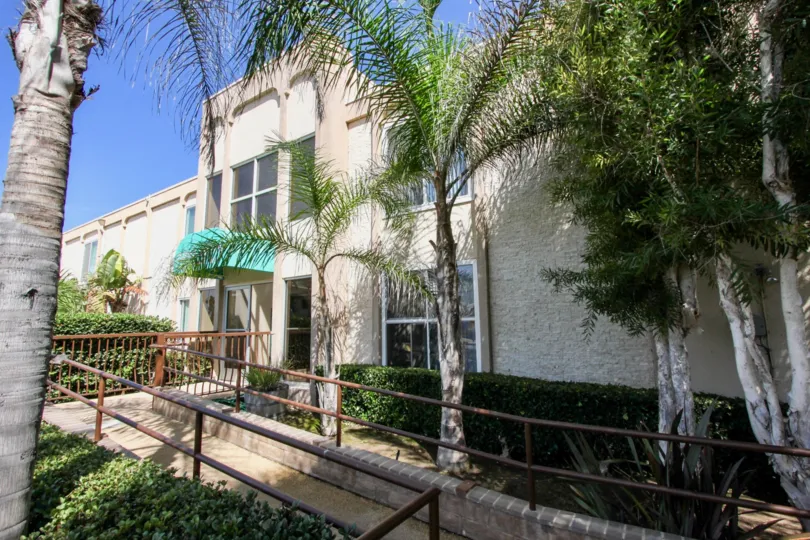 Two stroy house with large windows and a ramp to the front door, located in Puerta Del Sol, in Ocean Beach, California.