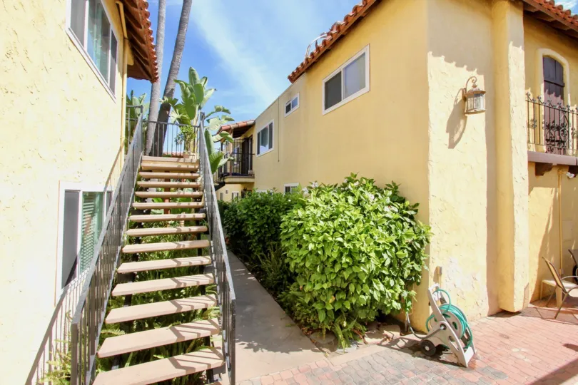 A staircase and a yellow house in Sand & Sea Villas neighborhood