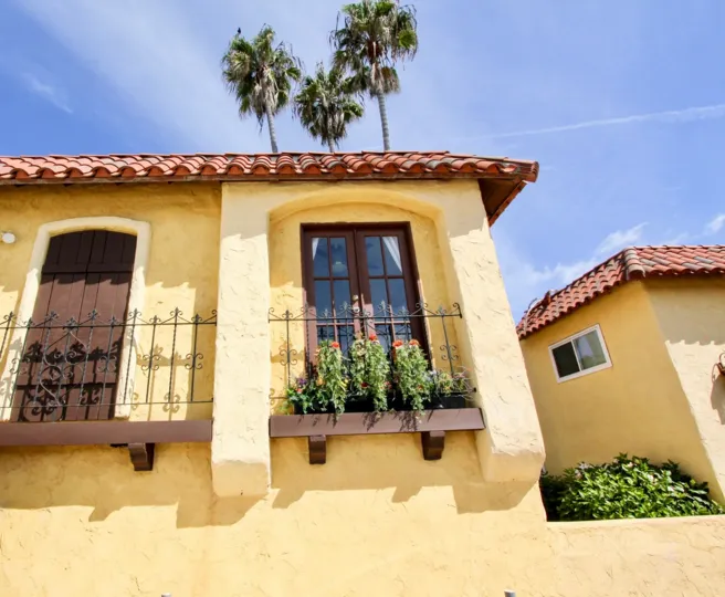 blue sky palm trees and big yellow house in Sand & Sea Villas