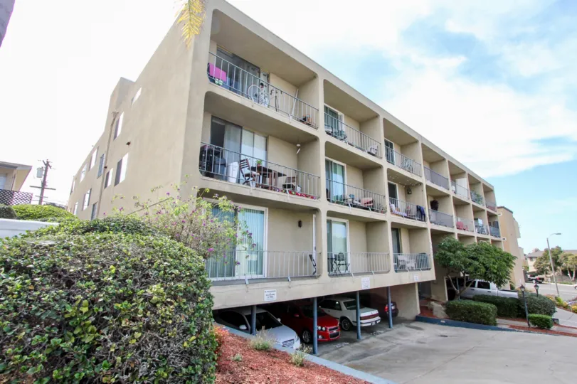 A tan building with patios sits under the blue sky in Sans Souci an Ocean Beach, CA town.