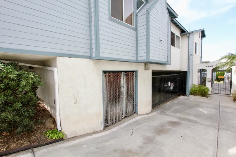 View of housing complex and a cement road leading towards that and bushes around at Spinnaker