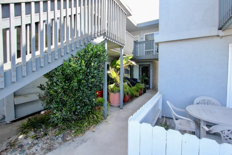 Under the stairs in Spray has bushes and flower pots and place dinning table in right side
