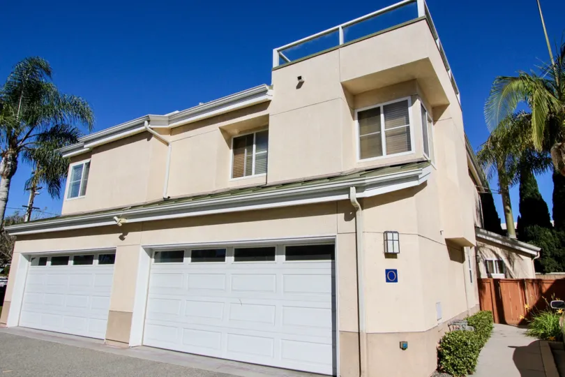 External view of double garage doors and two-story building at Eaton Court in Oceanside, California