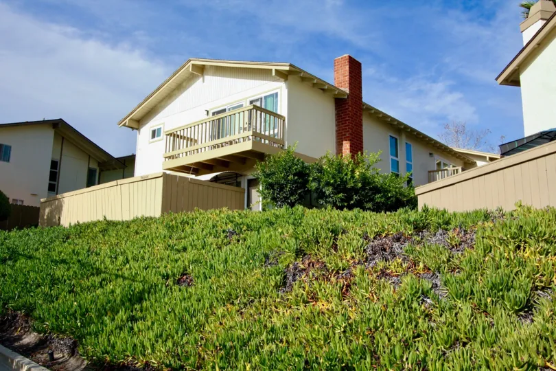 A balcony overlooking some shrubbery at El Camino Club Estates in Oceanside, CA.