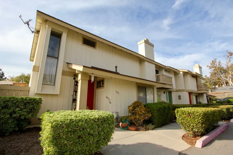 Bushes and a walkway in front of El Camino Club Estates in Oceanside, CA