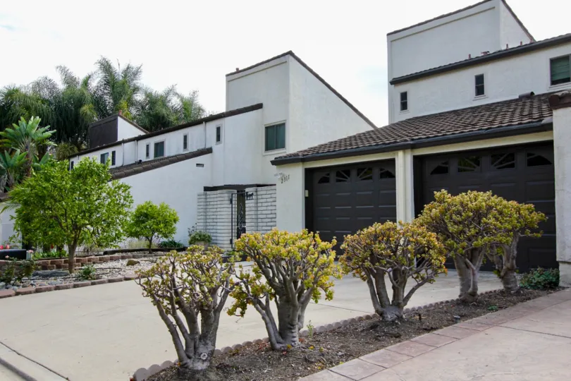 White homes with double garage are on a street in El Camino Villa.