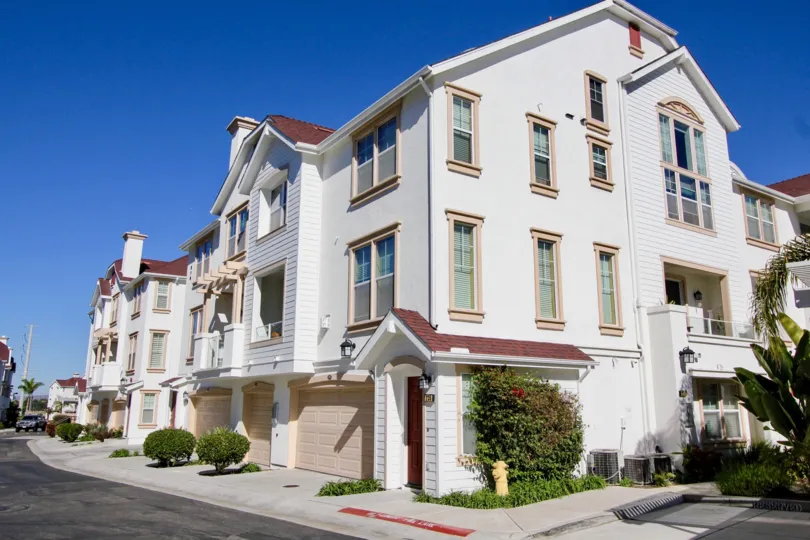 Three story residential building with flowered plants inside Harbor Cliff in Oceanside CA